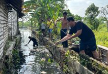 Reza Teguh Wibowo bersama warga saat melakukan kerja bakti pembersihan di sepanjang Kali Kepang, Kampung Tarogan, Kelurahan Kemayoran, Kecamatan Bangkalan, Minggu (21/12/2025).