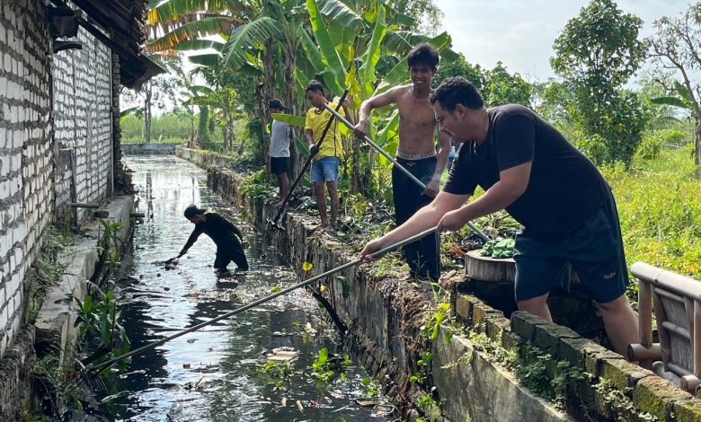 Reza Teguh Wibowo bersama warga saat melakukan kerja bakti pembersihan di sepanjang Kali Kepang, Kampung Tarogan, Kelurahan Kemayoran, Kecamatan Bangkalan, Minggu (21/12/2025).