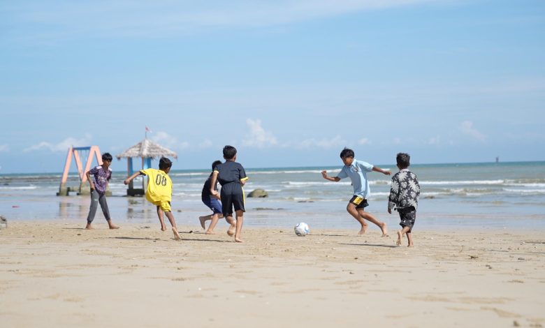 Anak-anak bermain sepak bola di Pantai Pasir Putih Tlangoh, Bangkalan, Jawa Timur. Pemulihan pesisir melalui pemasangan terumbu buatan hexa reef tak hanya menahan abrasi, tetapi juga menghidupkan kembali ruang publik dan aktivitas sosial warga di kawasan pantai.
