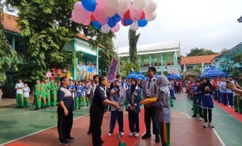 MERIAH – Kepala SMPN 1 Sampang, Teguh Suparyanto, membuka kegiatan class meeting dengan pelepasan balon udara di lapangan basket sekolah, Senin (15/12/2025). Kegiatan ini menjadi ajang pengembangan bakat dan kebersamaan siswa usai pelaksanaan ujian. (Ist)