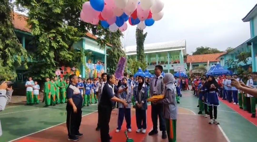 MERIAH – Kepala SMPN 1 Sampang, Teguh Suparyanto, membuka kegiatan class meeting dengan pelepasan balon udara di lapangan basket sekolah, Senin (15/12/2025). Kegiatan ini menjadi ajang pengembangan bakat dan kebersamaan siswa usai pelaksanaan ujian. (Ist)