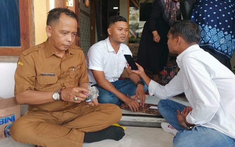 Owner SPPG Tambaan, Yayasan Babur Rizki, Eko Haryono (tengah), memberikan keterangan kepada wartawan terkait klarifikasi menu Makan Bergizi Gratis (MBG) di Kecamatan Camplong, Kabupaten Sampang, Senin (26/1/2026).