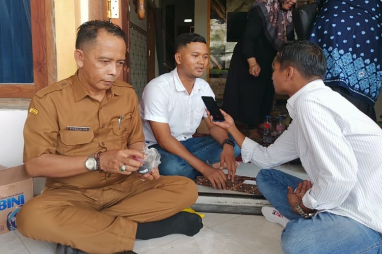 Owner SPPG Tambaan, Yayasan Babur Rizki, Eko Haryono (tengah), memberikan keterangan kepada wartawan terkait klarifikasi menu Makan Bergizi Gratis (MBG) di Kecamatan Camplong, Kabupaten Sampang, Senin (26/1/2026).