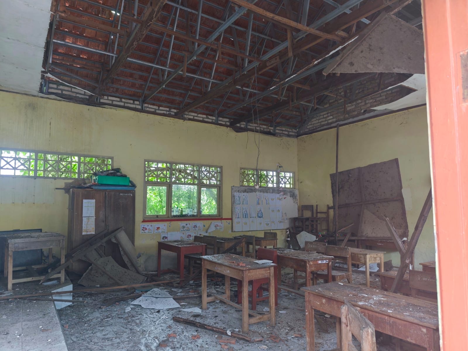 Kondisi ruang kelas 1 SDN Kramat 1 Bangkalan usai plafon ambruk saat kegiatan belajar mengajar berlangsung, Rabu (28/1/2026). Puing-puing plafon berserakan di lantai dan menimpa meja serta perlengkapan siswa. Seluruh siswa berhasil dievakuasi dan tidak ada korban jiwa.