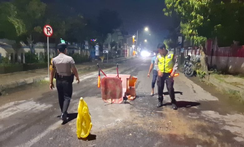 Pihak kepolisian saat melakukan penambalan jalan usai kecelakaan