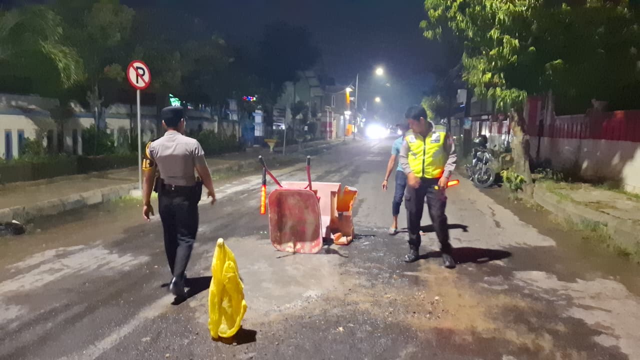 Pihak kepolisian saat melakukan penambalan jalan usai kecelakaan