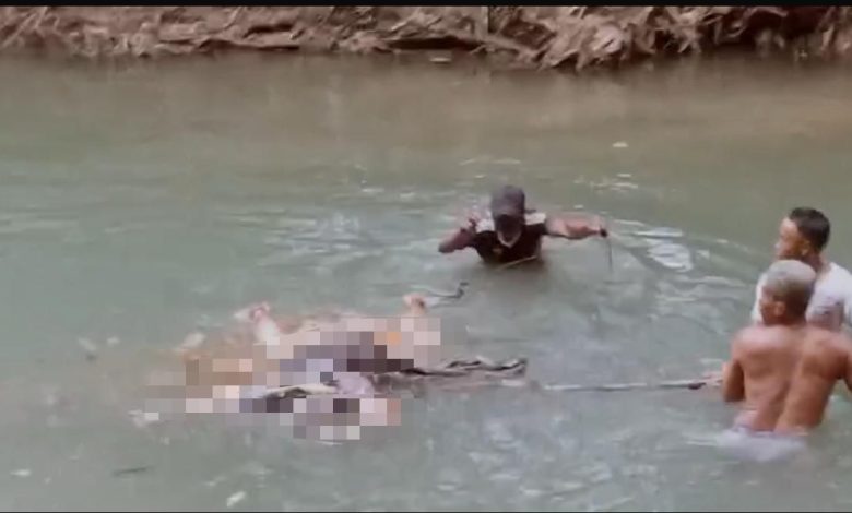 Petugas dan warga mengevakuasi sesosok mayat laki-laki tanpa identitas yang ditemukan mengambang di aliran sungai Desa Tellok, Kecamatan Galis, Bangkalan, Sabtu (21/2/2026) sore.**