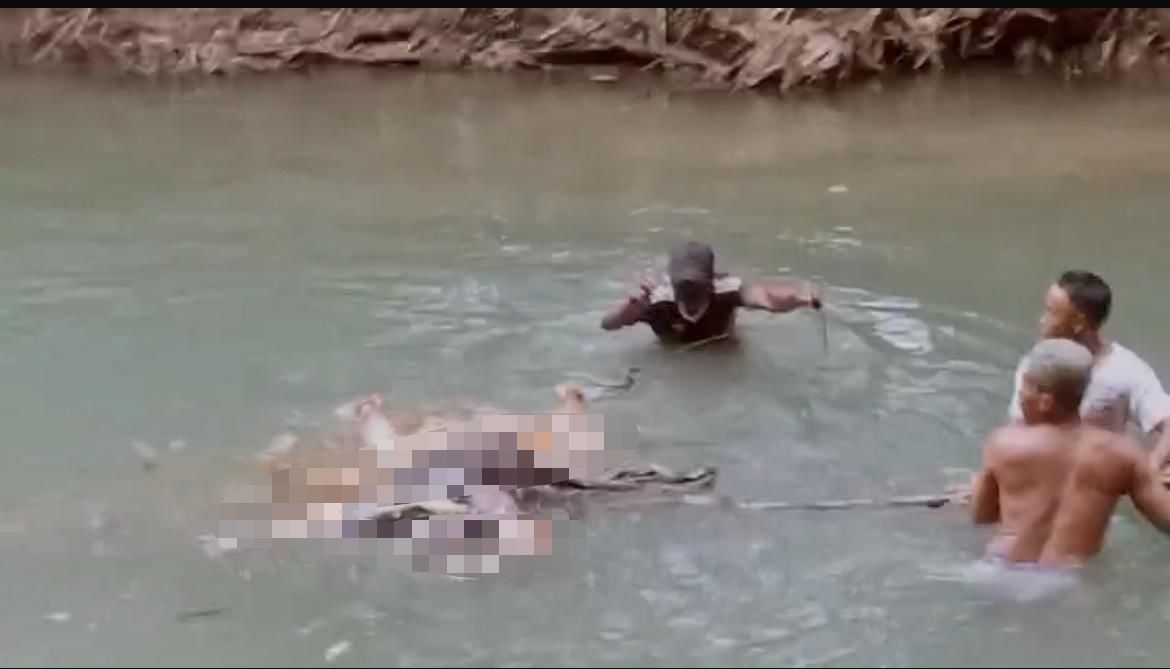 Petugas dan warga mengevakuasi sesosok mayat laki-laki tanpa identitas yang ditemukan mengambang di aliran sungai Desa Tellok, Kecamatan Galis, Bangkalan, Sabtu (21/2/2026) sore.**