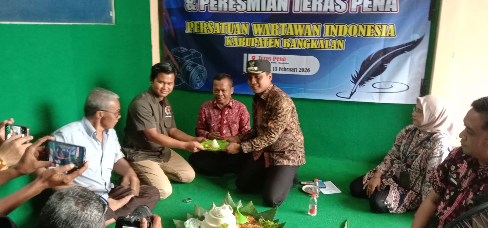 Prosesi pemotongan tumpeng dalam peringatan Hari Pers Nasional 2026 sekaligus peresmian sekretariat “Teras Pena” PWI Kabupaten Bangkalan, Jumat (13/2/2026).