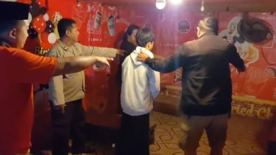 Petugas saat mengamankan terduga pelaku dugaan tindak pidana asusila yang videonya viral di Kecamatan Tambelangan, Kabupaten Sampang.