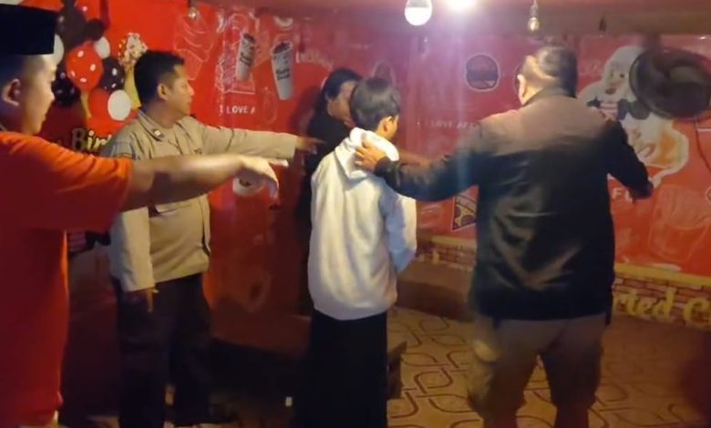 Petugas saat mengamankan terduga pelaku dugaan tindak pidana asusila yang videonya viral di Kecamatan Tambelangan, Kabupaten Sampang.