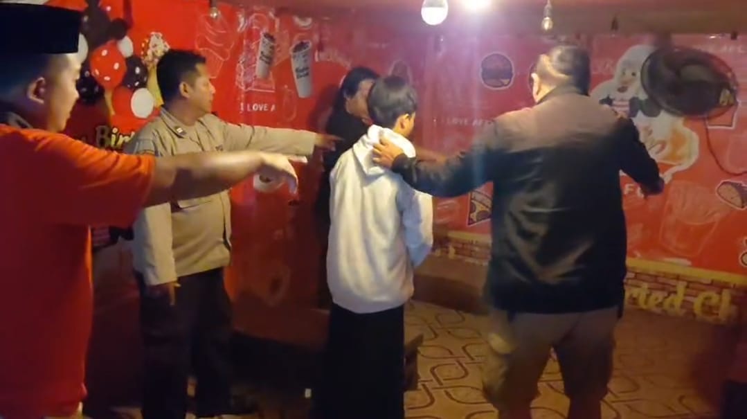 Petugas saat mengamankan terduga pelaku dugaan tindak pidana asusila yang videonya viral di Kecamatan Tambelangan, Kabupaten Sampang.