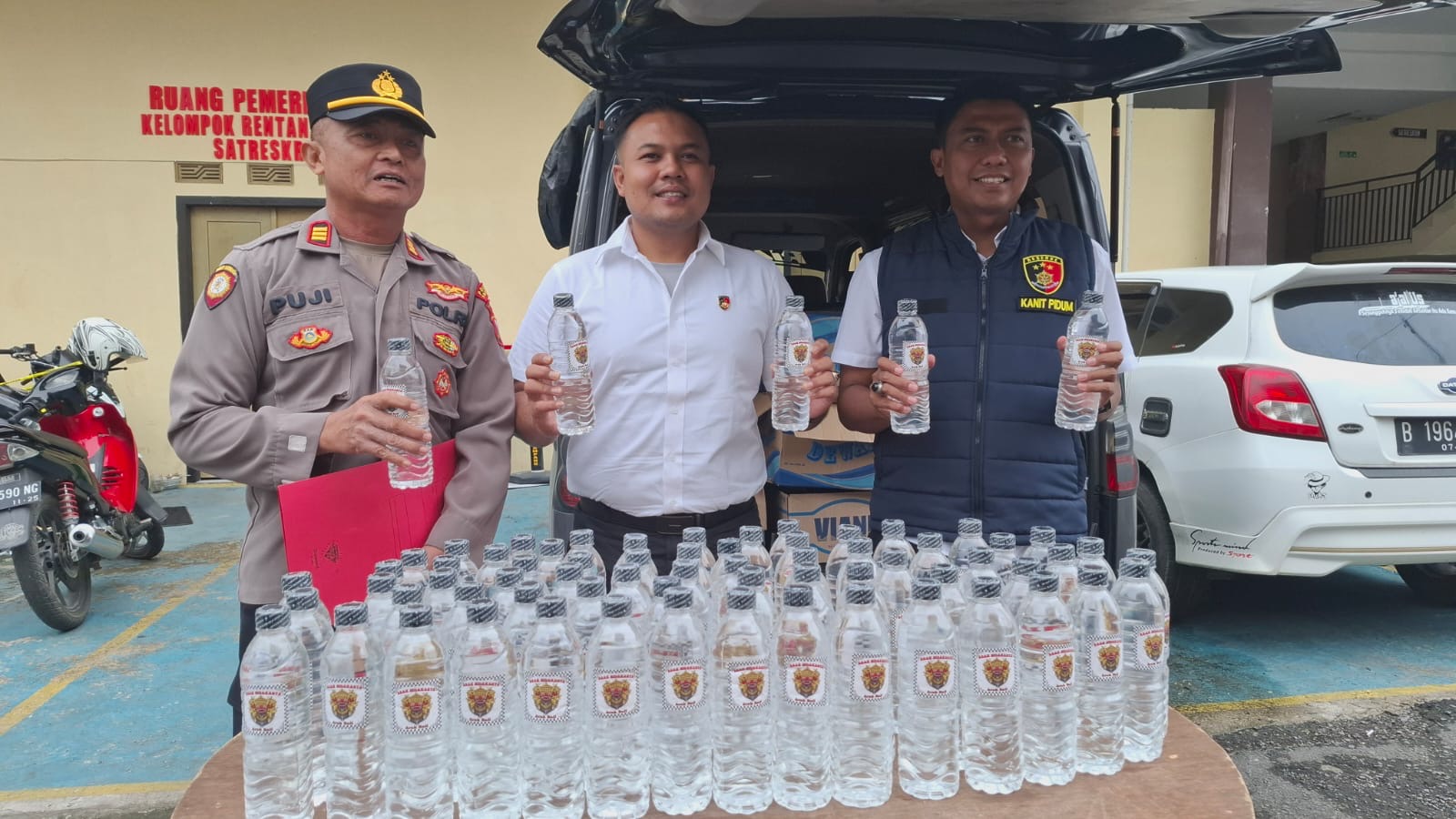 Petugas Satreskrim Polres Sampang menunjukkan barang bukti minuman keras jenis Arak Bali yang berhasil diamankan dari sebuah mobil travel di kawasan Terminal Trunojoyo, Sampang.