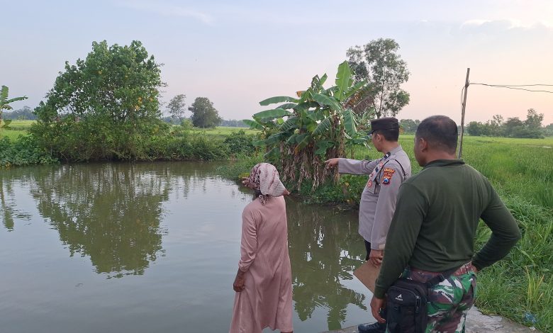 Petugas kepolisian bersama warga menunjukkan lokasi kubangan Sungai Torjun di Dusun Cangginih, Desa Bringin Nunggal, Kecamatan Torjun, Sampang, tempat dua balita dilaporkan tenggelam, Minggu (15/2/2026) sore.