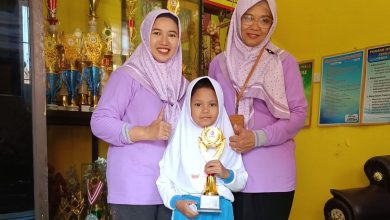 Keterangan Foto: Foto: Nadia Hairul Putri Hidayati, siswi SDN Kraton 2 Bangkalan, saat memegang piala bersama Kepala Sekolah Erma Agustiningsih (kanan).
