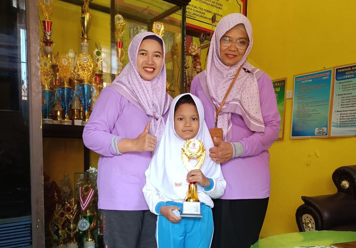 Keterangan Foto: Foto: Nadia Hairul Putri Hidayati, siswi SDN Kraton 2 Bangkalan, saat memegang piala bersama Kepala Sekolah Erma Agustiningsih (kanan).