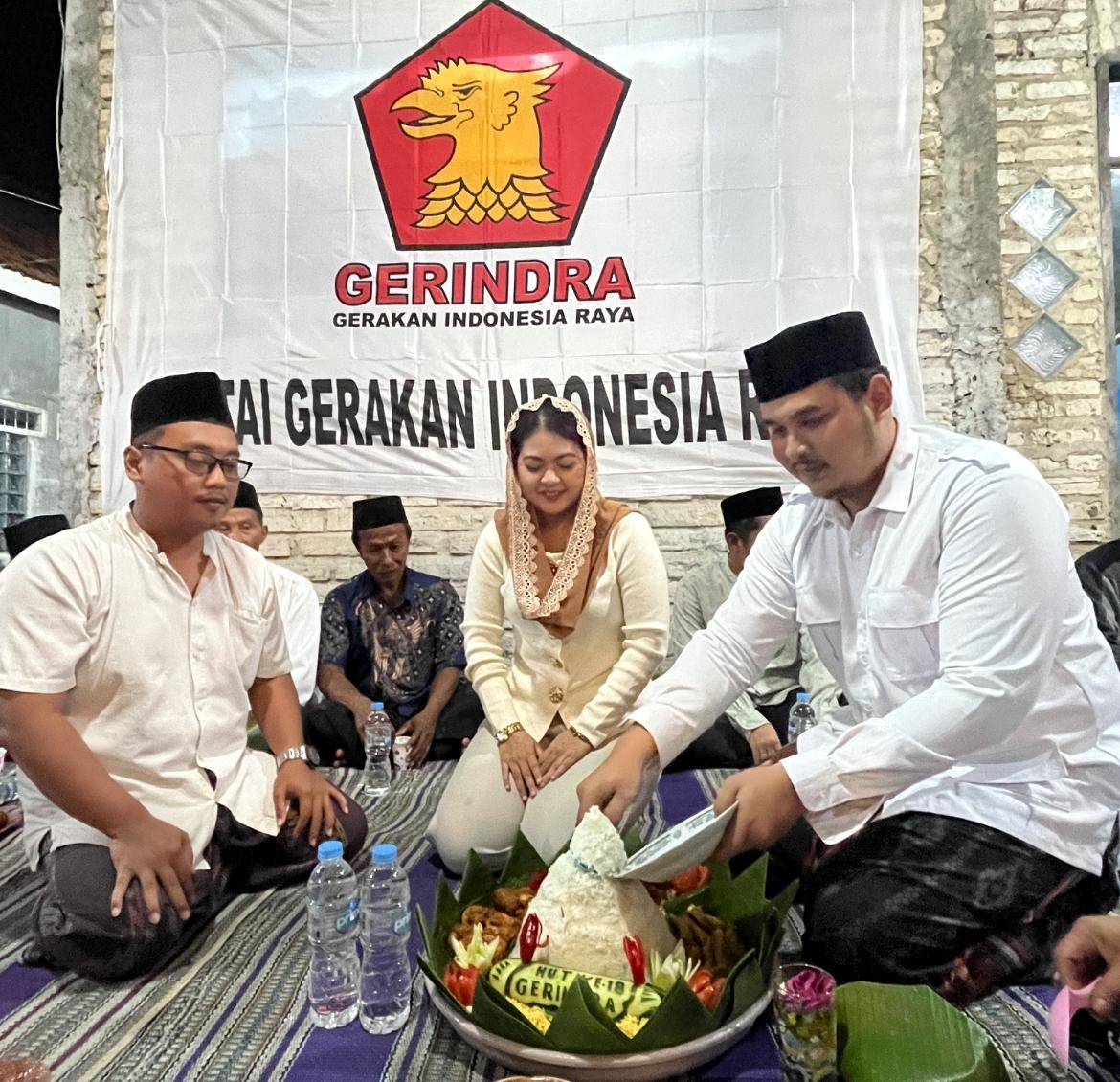 Ketua Komisi III DPRD Kabupaten Bangkalan, Reza Teguh Wibowo, saat memotong tumpeng pada acara tasyakkuran Hari Ulang Tahun (HUT) ke-18 Partai Gerindra di Kampung Kepang Tarogan, Kelurahan Kemayoran, Kecamatan Bangkalan, Sabtu (7/2/2026).