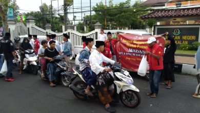 Pengurus dan anggota Madas Serumpun DPC Bangkalan saat membagikan 5.000 paket takjil gratis kepada pengguna jalan di depan Taman Makam Pahlawan Bangkalan, Selasa (17/3/2026).