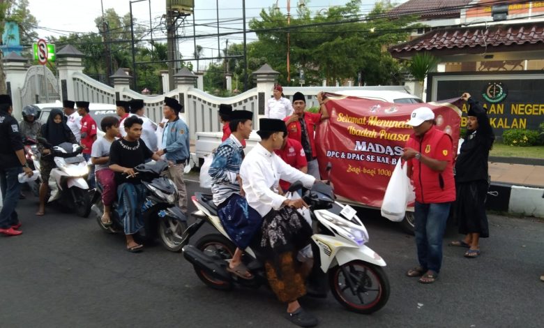 Pengurus dan anggota Madas Serumpun DPC Bangkalan saat membagikan 5.000 paket takjil gratis kepada pengguna jalan di depan Taman Makam Pahlawan Bangkalan, Selasa (17/3/2026).