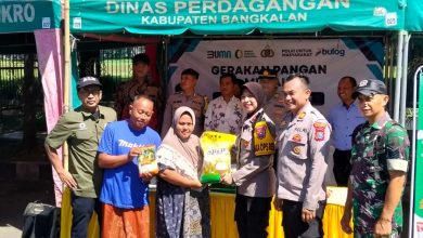 Petugas Polres Bangkalan bersama Perum Bulog Kantor Cabang Madura menyerahkan secara simbolis bahan pokok kepada warga dalam kegiatan Gerakan Pangan Murah (GPM) di stan Dinas Perdagangan Kabupaten Bangkalan, Jumat (13/3/2026). Program ini digelar untuk menjaga stabilitas harga pangan dan membantu masyarakat menjelang Hari Raya Idul Fitri.