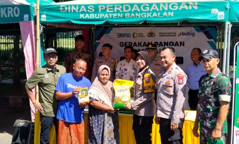 Petugas Polres Bangkalan bersama Perum Bulog Kantor Cabang Madura menyerahkan secara simbolis bahan pokok kepada warga dalam kegiatan Gerakan Pangan Murah (GPM) di stan Dinas Perdagangan Kabupaten Bangkalan, Jumat (13/3/2026). Program ini digelar untuk menjaga stabilitas harga pangan dan membantu masyarakat menjelang Hari Raya Idul Fitri.