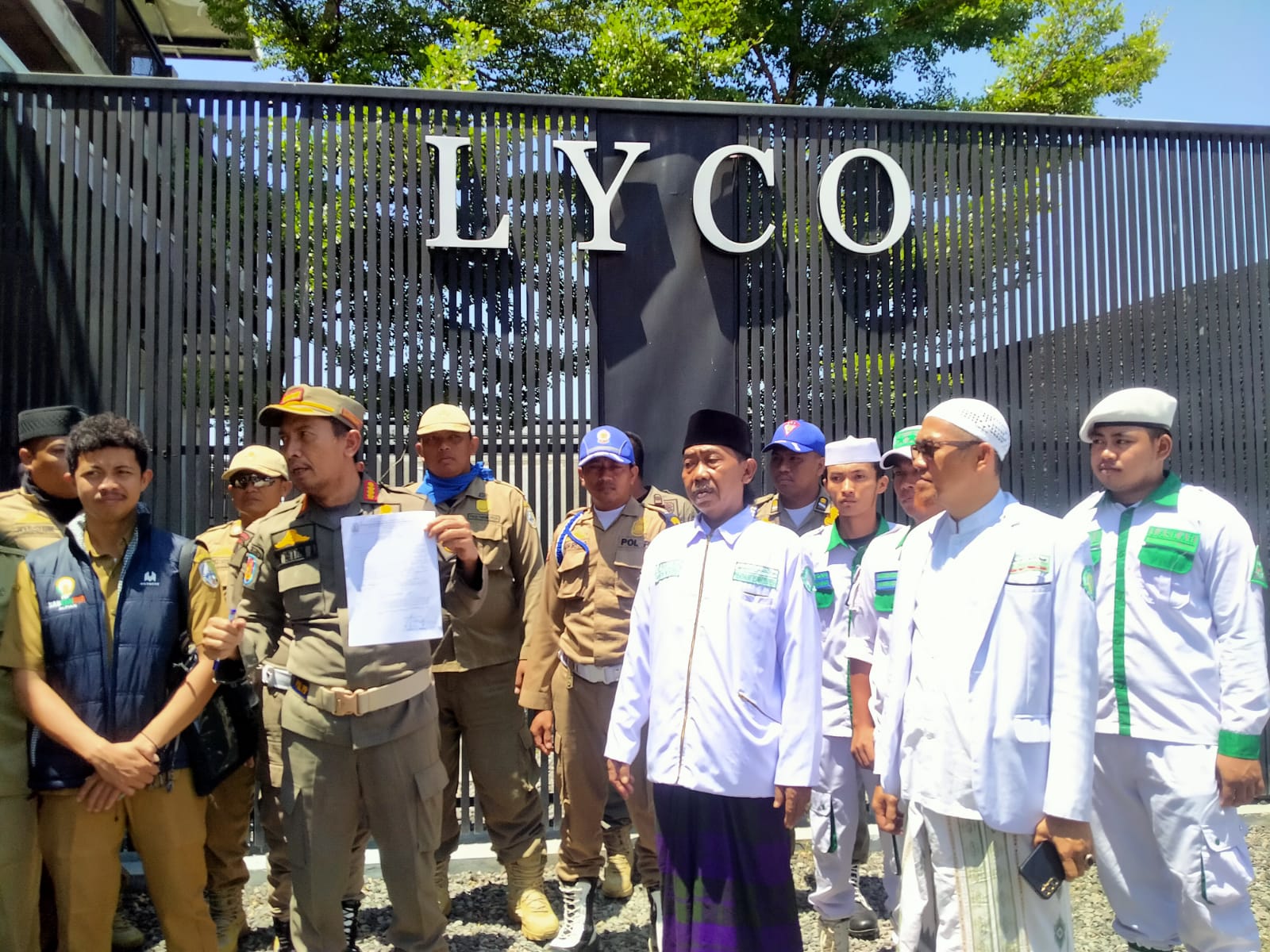 Petugas Satpol PP Kabupaten Sampang bersama sejumlah tokoh masyarakat menunjukkan surat keputusan penutupan sementara Lyco Cafe di Jalan Syamsul Arifien, Kelurahan Polagan, Kecamatan Sampang, Senin (16/3/2026).