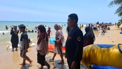 Suasana ramai pengunjung di Pantai Lon Malang saat libur Lebaran 2026, dengan petugas BPBD bersiaga di lokasi untuk memastikan keamanan dan keselamatan wisatawan.