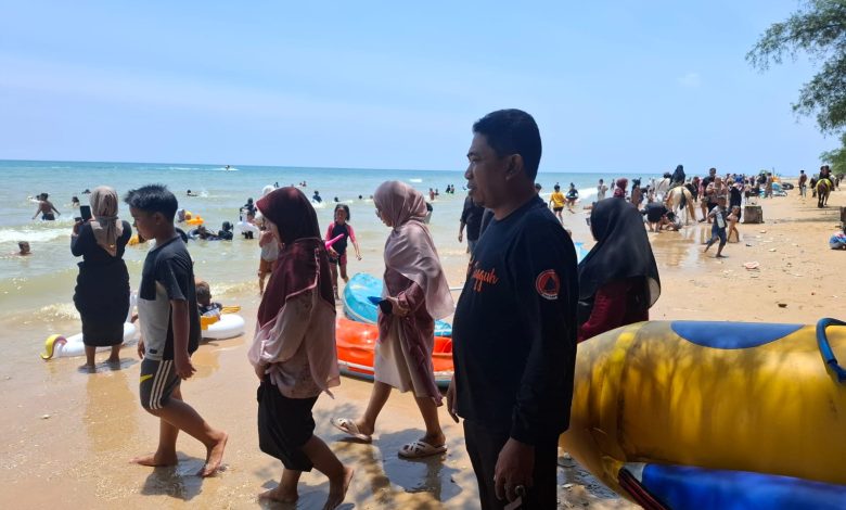 Suasana ramai pengunjung di Pantai Lon Malang saat libur Lebaran 2026, dengan petugas BPBD bersiaga di lokasi untuk memastikan keamanan dan keselamatan wisatawan.