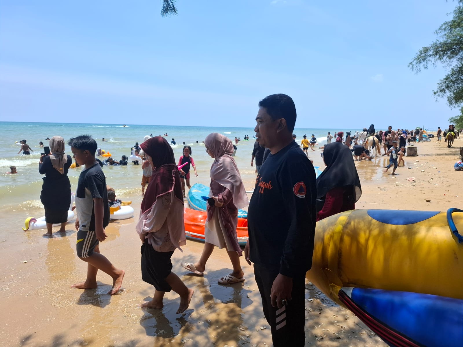 Suasana ramai pengunjung di Pantai Lon Malang saat libur Lebaran 2026, dengan petugas BPBD bersiaga di lokasi untuk memastikan keamanan dan keselamatan wisatawan.