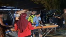 Petugas dan warga mengevakuasi korban kecelakaan dari mobil pikap ke ambulans di Jalan Halim Perdana Kusuma, Bancaran, Bangkalan, Minggu malam (5/4/2026). Insiden tabrak belakang tersebut menewaskan satu orang dan menyebabkan empat lainnya luka-luka.