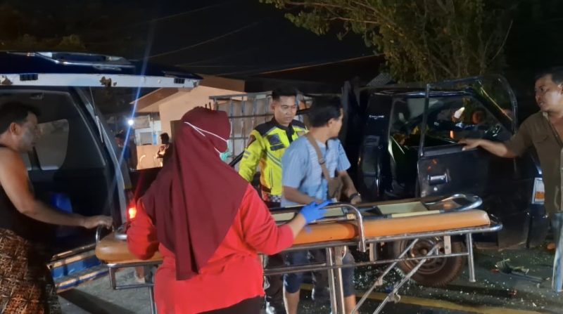 Petugas dan warga mengevakuasi korban kecelakaan dari mobil pikap ke ambulans di Jalan Halim Perdana Kusuma, Bancaran, Bangkalan, Minggu malam (5/4/2026). Insiden tabrak belakang tersebut menewaskan satu orang dan menyebabkan empat lainnya luka-luka.