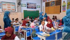 Guru SDN Demangan 1 Bangkalan mengenakan kebaya saat mengajar dan membagikan makanan kepada siswa dalam rangka memperingati Hari Kartini, mengenang perjuangan Raden Ajeng Kartini di dunia pendidikan.