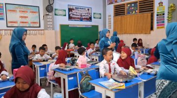 Guru SDN Demangan 1 Bangkalan mengenakan kebaya saat mengajar dan membagikan makanan kepada siswa dalam rangka memperingati Hari Kartini, mengenang perjuangan Raden Ajeng Kartini di dunia pendidikan.