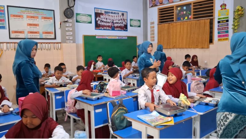 Guru SDN Demangan 1 Bangkalan mengenakan kebaya saat mengajar dan membagikan makanan kepada siswa dalam rangka memperingati Hari Kartini, mengenang perjuangan Raden Ajeng Kartini di dunia pendidikan.