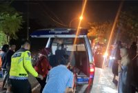 Petugas kepolisian dibantu warga mengevakuasi korban dari mobil pikap yang ringsek parah usai menabrak truk tronton di Jalan Halim Perdana Kusuma, Bancaran, Bangkalan, Minggu malam (5/4/2026). Satu orang meninggal dunia, sementara empat lainnya mengalami luka-luka.
