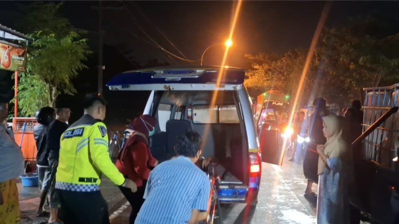 Petugas kepolisian dibantu warga mengevakuasi korban dari mobil pikap yang ringsek parah usai menabrak truk tronton di Jalan Halim Perdana Kusuma, Bancaran, Bangkalan, Minggu malam (5/4/2026). Satu orang meninggal dunia, sementara empat lainnya mengalami luka-luka.