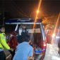 Petugas kepolisian dibantu warga mengevakuasi korban dari mobil pikap yang ringsek parah usai menabrak truk tronton di Jalan Halim Perdana Kusuma, Bancaran, Bangkalan, Minggu malam (5/4/2026). Satu orang meninggal dunia, sementara empat lainnya mengalami luka-luka.