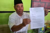 Pengasuh Ponpes Darul Muttaqin, KH Takliman, menunjukkan surat kritik yang dilayangkan kepada Kementerian Agama Republik Indonesia terkait polemik penentuan 1 Syawal.