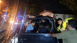 Petugas kepolisian dibantu warga mengevakuasi korban dari mobil pikap yang ringsek parah usai menabrak truk tronton di Jalan Halim Perdana Kusuma, Bancaran, Bangkalan, Minggu malam (5/4/2026). Satu orang meninggal dunia, sementara empat lainnya mengalami luka-luka.
