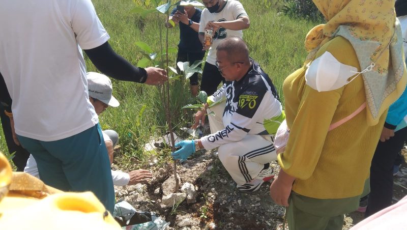 Petugas DLH Bangkalan bersama sejumlah pegawai melakukan penanaman bibit pohon di lingkungan OPD sebagai upaya penghijauan dan menghadapi dampak perubahan iklim.