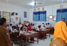 Petugas sekolah memeriksa ponsel siswa dalam razia penggunaan media sosial di SDN Demangan 1 Bangkalan.