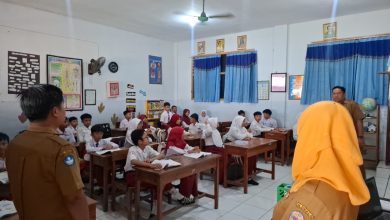Petugas sekolah memeriksa ponsel siswa dalam razia penggunaan media sosial di SDN Demangan 1 Bangkalan.