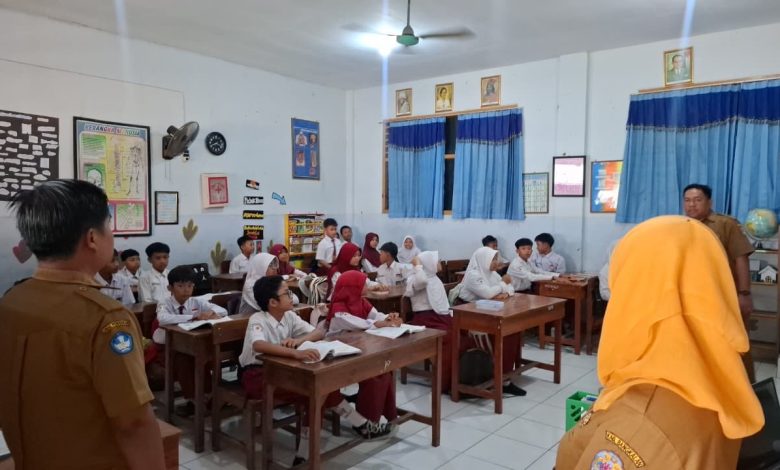 Petugas sekolah memeriksa ponsel siswa dalam razia penggunaan media sosial di SDN Demangan 1 Bangkalan.