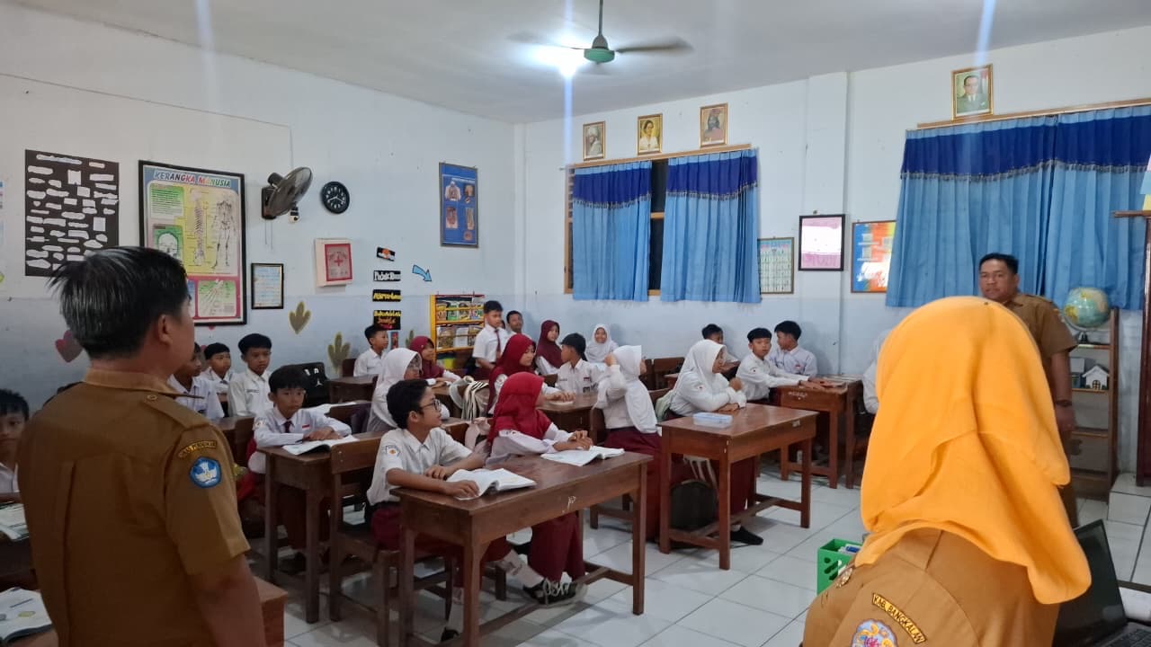 Petugas sekolah memeriksa ponsel siswa dalam razia penggunaan media sosial di SDN Demangan 1 Bangkalan.
