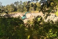 Alat berat excavator beroperasi di lokasi tambang galian C di Desa Sentol Laok, Sumenep, yang dikeluhkan warga karena dekat dengan permukiman dan dinilai membahayakan.