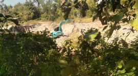 Alat berat excavator beroperasi di lokasi tambang galian C di Desa Sentol Laok, Sumenep, yang dikeluhkan warga karena dekat dengan permukiman dan dinilai membahayakan.