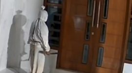 Tangkapan layar CCTV yang memperlihatkan sosok berkostum pocong berdiri di depan rumah warga di Desa Larangan Glintong, Kecamatan Klampis, Bangkalan. Aksi yang sempat viral dan meresahkan warga itu belakangan diketahui hanya konten buatan sejumlah pemuda untuk media sosial.