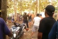Tangkapan layar video yang memperlihatkan suasana ricuh di arena sabung ayam di wilayah perbatasan Bangkalan dan Sampang. Keributan diduga dipicu sengketa taruhan hingga sejumlah warga terlihat saling mengacungkan senjata tajam jenis celurit.