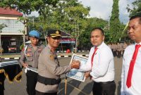 Kapolres Sampang AKBP Hartono menyerahkan penghargaan kepada Kasat Reskrim Iptu Nur Fajri Alim atas keberhasilannya mengungkap 27 kasus asusila terhadap anak dan sindikat curanmor lintas wilayah dalam upacara di Mapolres Sampang, Rabu (15/7/2026).