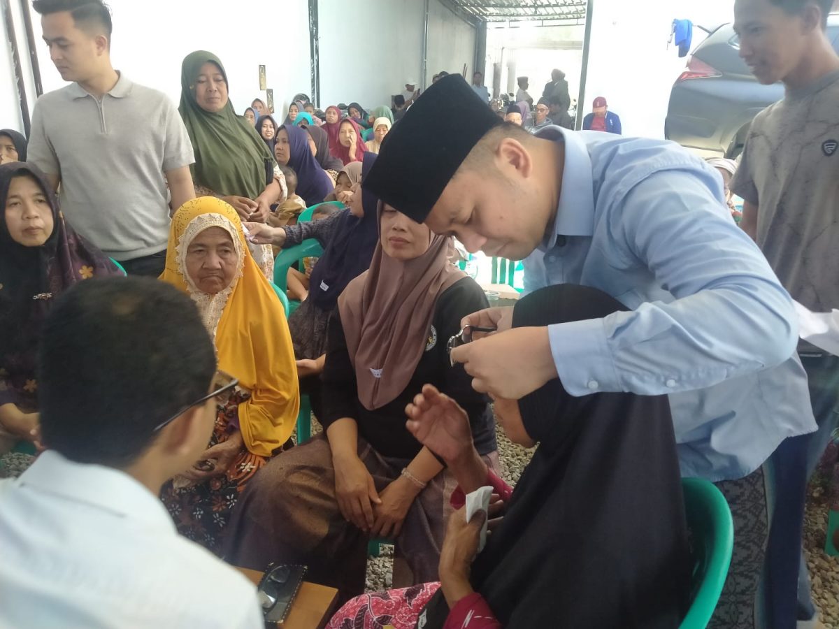 Petugas medis memeriksa kondisi mata salah seorang warga dalam kegiatan bakti sosial pemeriksaan mata dan pembagian kacamata gratis yang digelar Anggota DPR RI Fraksi PAN, H. Slamet Ariyadi, di Kecamatan Camplong, Kabupaten Sampang, Rabu (5/8/2026).